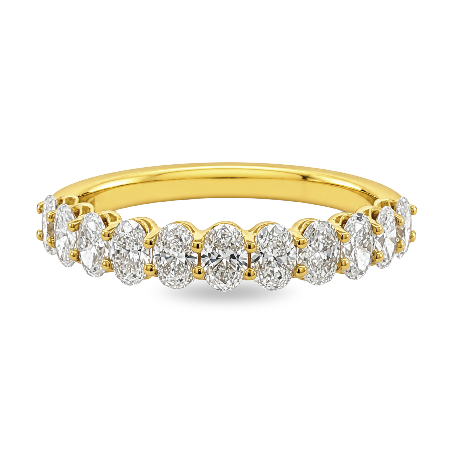A yellow gold band ring set with a row of oval cut diamonds, shown on a clean white background.