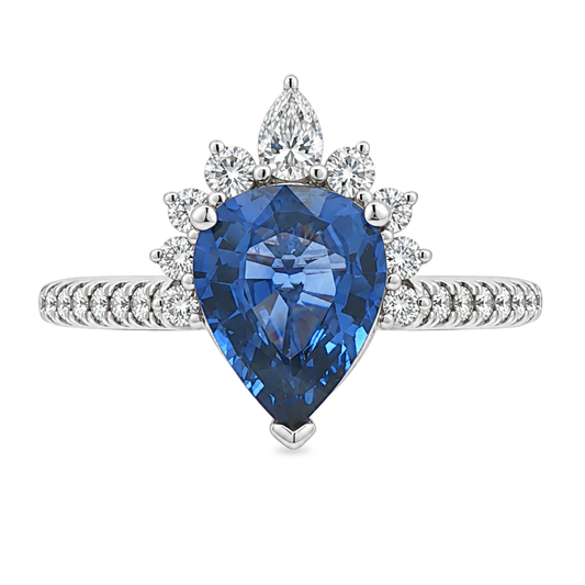 White gold ring set with a pear shape blue sapphire with a graduated half halo of diamonds and diamonds on the band. Set on a clean white background.