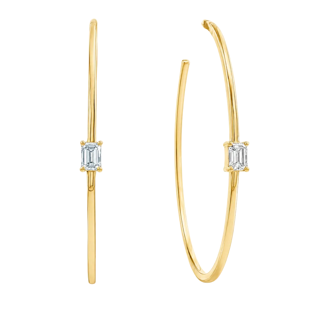 A pair of gold hoop earrings with a single rectangular baguette diamond in a prong setting on each earring, shown against a plain white background.
