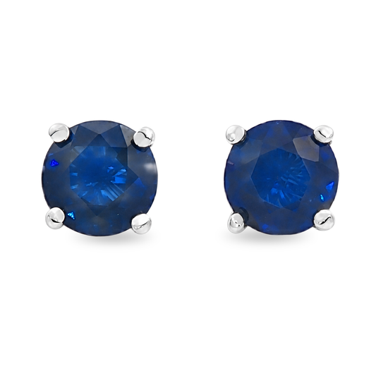 Round blue sapphire stud earrings set in white gold, shown on a clean white background