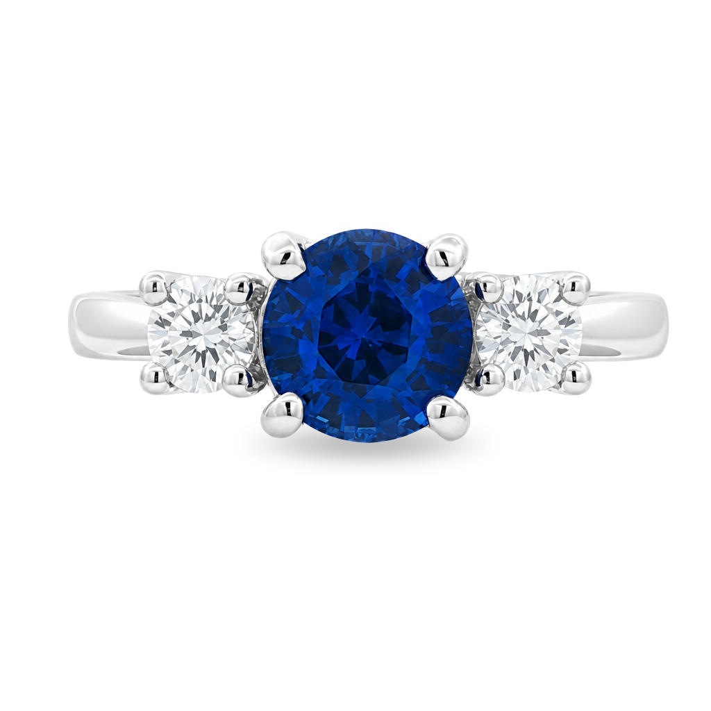 White gold ring with a round blue sapphire flanked by diamonds set on white background