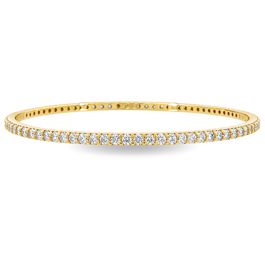 Yellow gold bangle set with a continuous row of round brilliant diamonds. Set on a clean white background. 