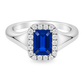A white gold ring featuring a rectangular emerald-cut blue sapphire center stone surrounded by a halo of small round-cut diamonds. Set on a clean white background.