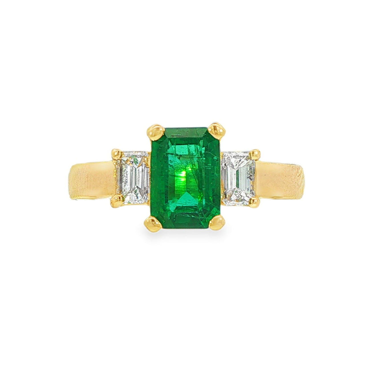 18K Yellow gold ring set with an emerald cut emerald and two baguette diamonds. Item J31312 - ABC Jewelry Co.