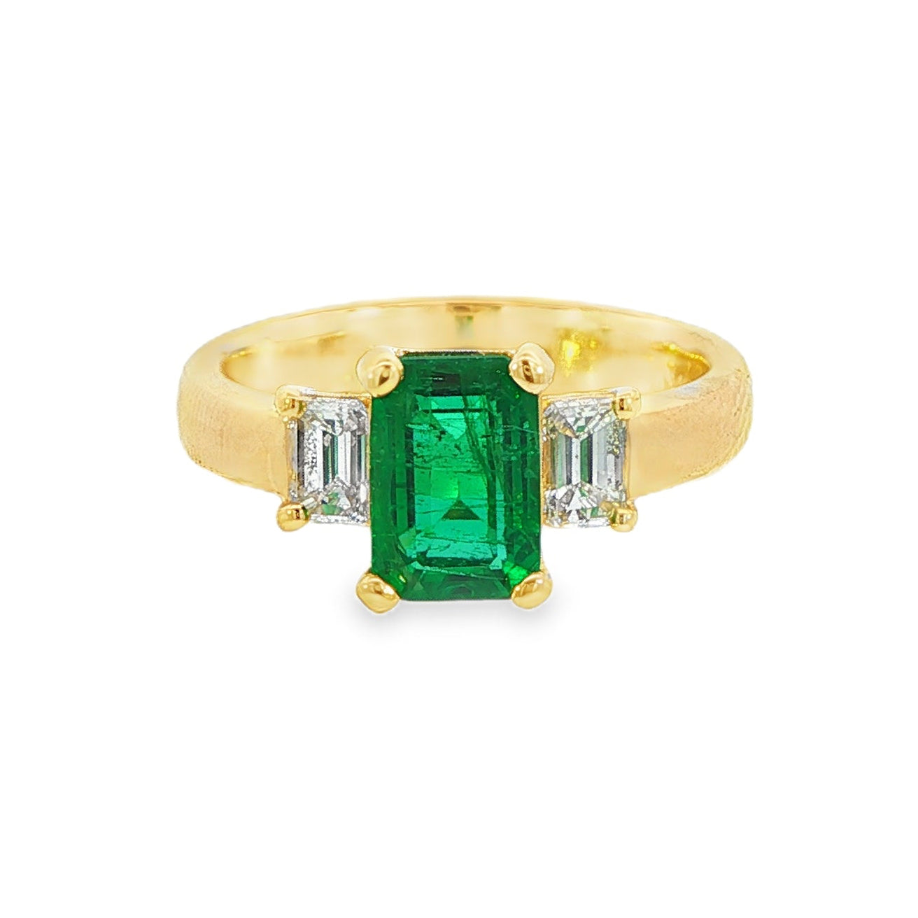 18K Yellow gold ring set with an emerald cut emerald and two baguette diamonds. Item J31312 - ABC Jewelry Co.