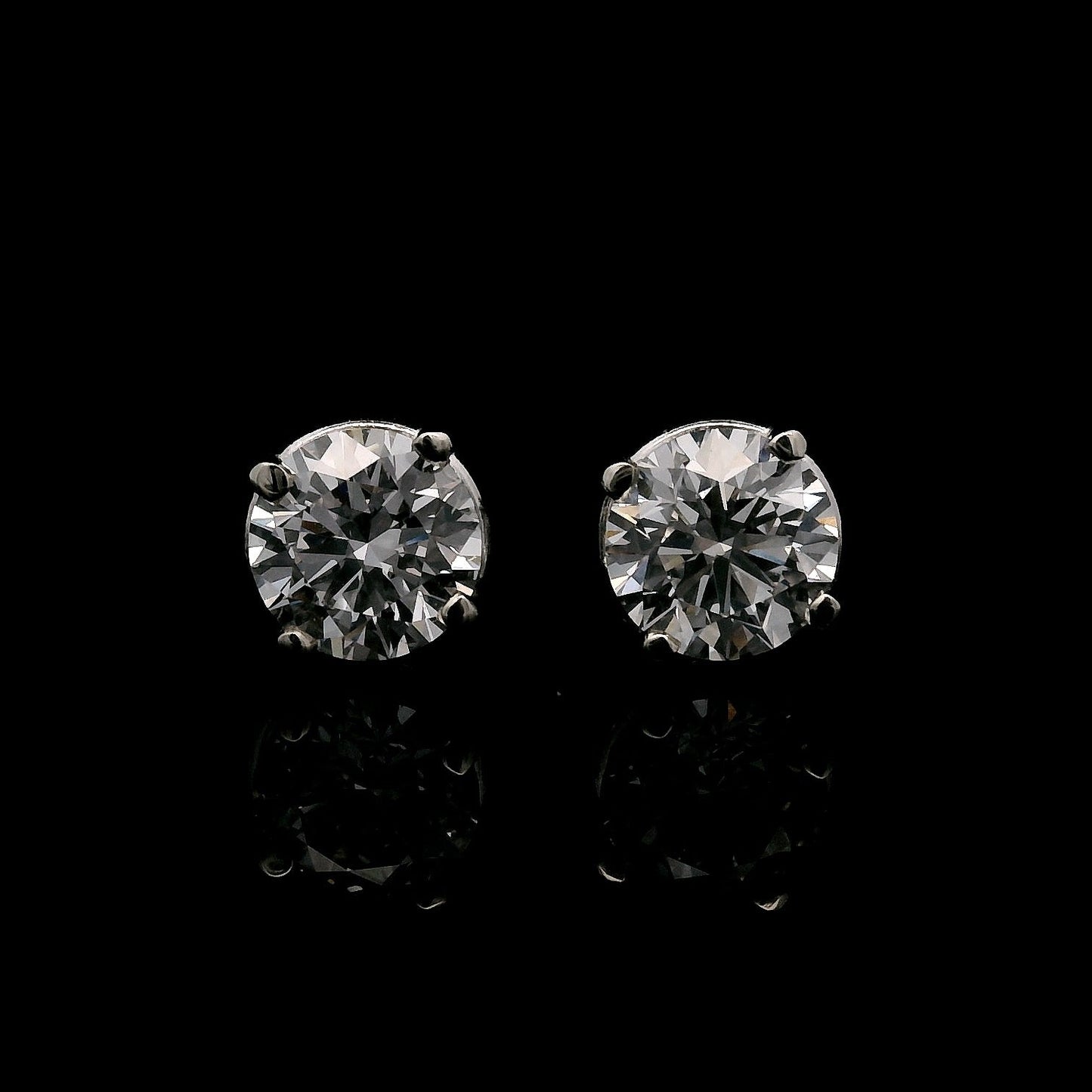 14K White gold stud earrings set with 2 round brilliant diamonds. Item J34919 - ABC Jewelry Co. 