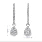 18K White gold earring jackets featuring clusters of diamonds, shown on white gold diamond hoop earrings. Item J35758 - ABC Jewelry Co