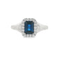 14K White gold ring set with an emerald cut deep blue sapphire surrounded by a halo of round brilliant diamonds. Item J35826 - ABC Jewelry Co. 