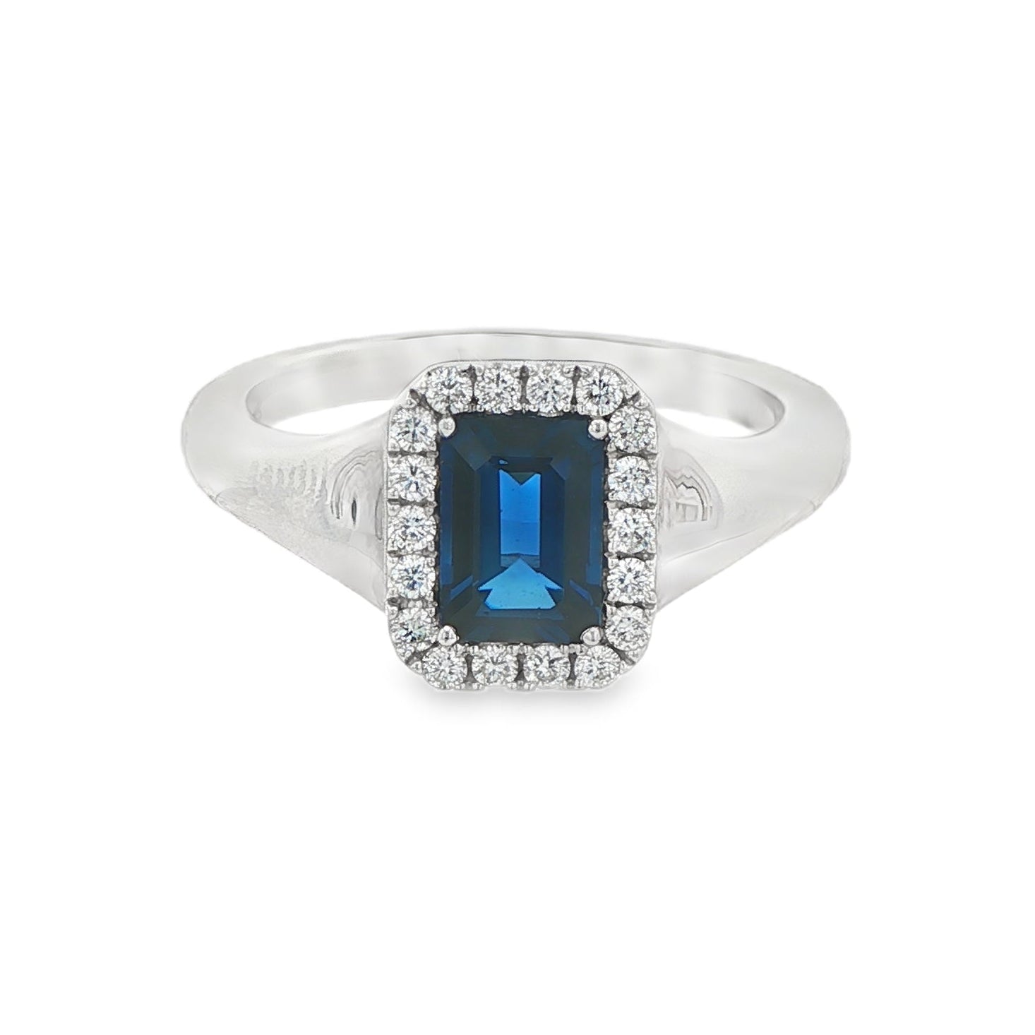 14K White gold ring set with an emerald cut deep blue sapphire surrounded by a halo of round brilliant diamonds. Item J35826 - ABC Jewelry Co. 