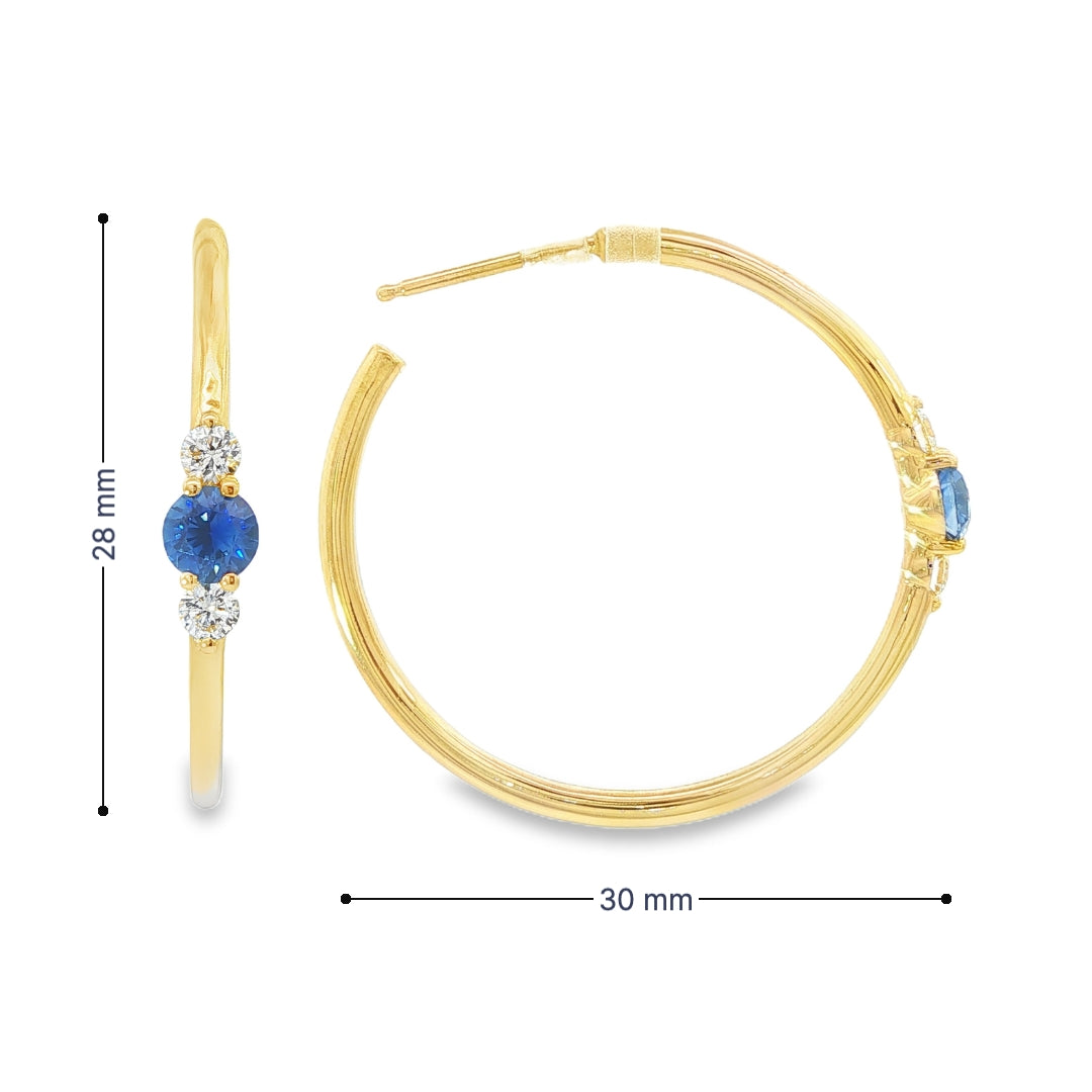 14K Yellow gold hoop earrings, each set with a round blue sapphire flanked by two round diamonds. Item - J39003 - ABC Jewelry Co. 