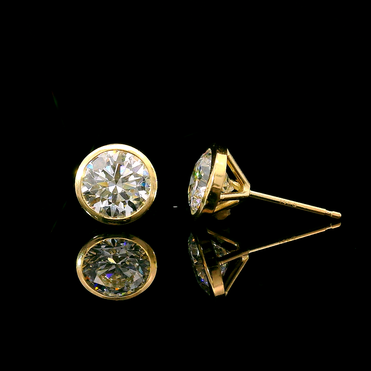 Yellow gold bezel set stud earrings set with round brilliant diamonds