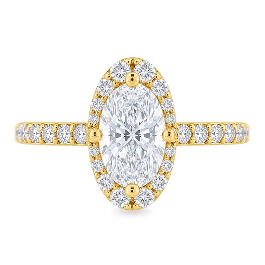Yellow gold ring with round diamonds on the band and a diamond halo, set with an elongated oval diamond set on a white background.