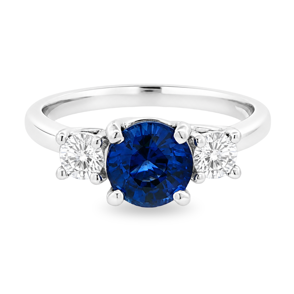 White gold ring with a round blue sapphire flanked by diamonds set on white background