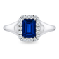 A white gold ring featuring a rectangular emerald-cut blue sapphire center stone surrounded by a halo of small round-cut diamonds. Set on a clean white background.