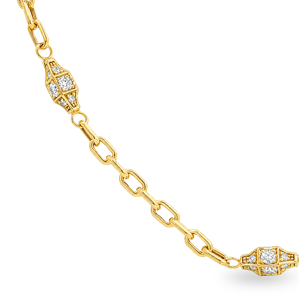 A close-up of a yellow gold chain bracelet featuring decorative geometric links set with small clear stones, shown on a plain white background.