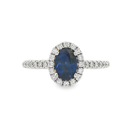 18K White gold ring set with an oval blue sapphire surrounded by a diamond halo. Item J30904 - ABC Jewelry Co. 
