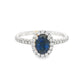 18K White gold ring set with an oval blue sapphire surrounded by a diamond halo. Item J30904 - ABC Jewelry Co. 
