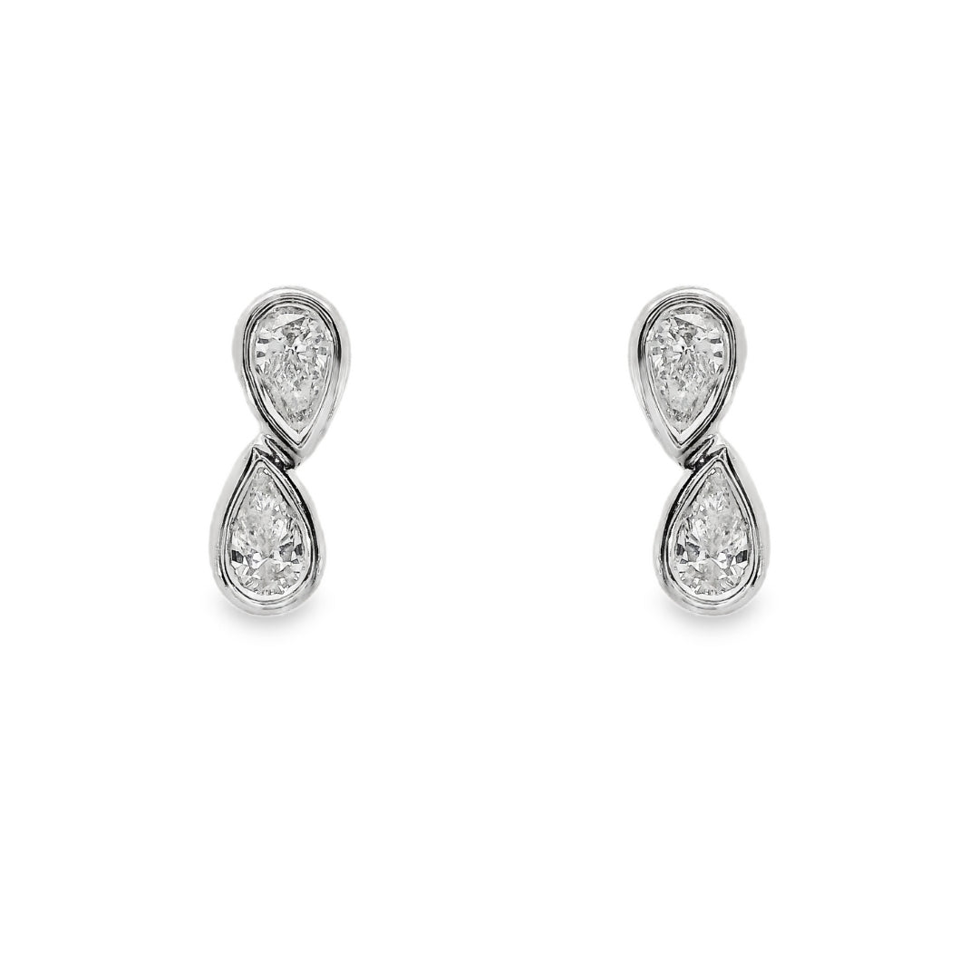 18K White gold diamond earrings, each set with two pear shape diamonds in a vertical design. Item J37096 - ABC Jewelry Co
