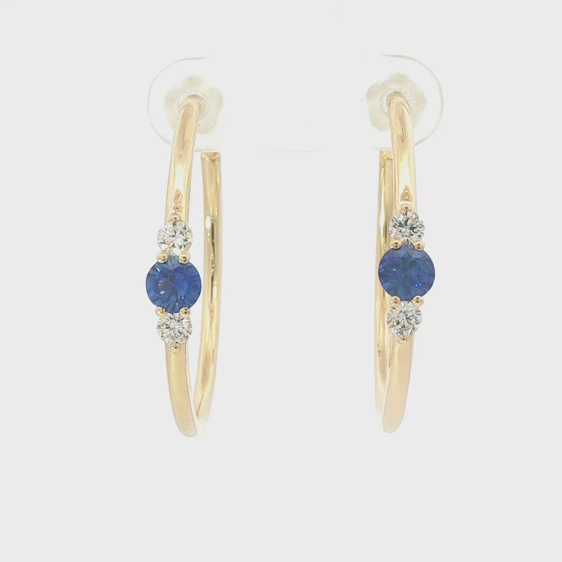 14K Yellow gold hoop earrings, each set with a round blue sapphire flanked by two round diamonds. Item - J39003 - ABC Jewelry Co. 