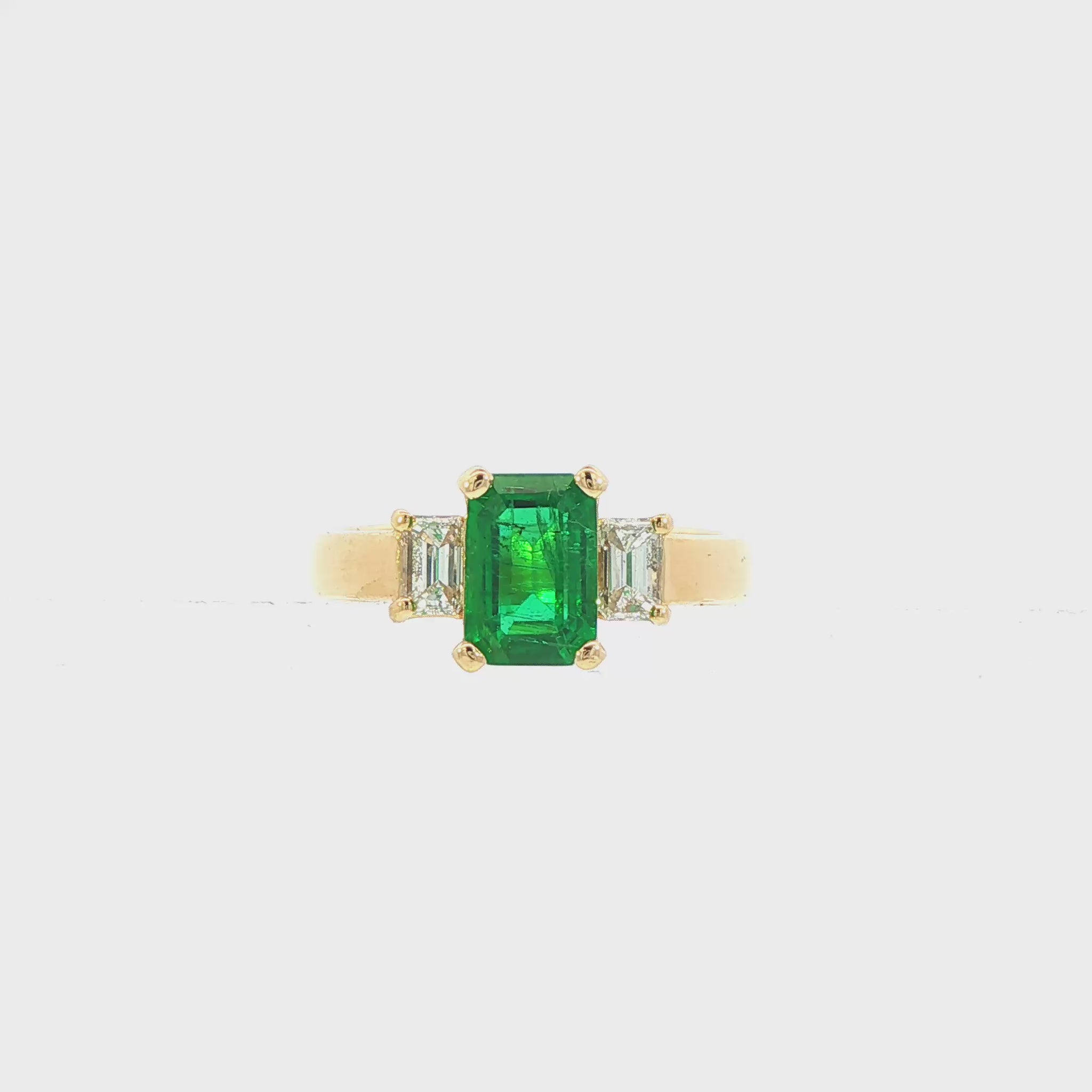 18K Yellow gold ring set with an emerald cut emerald and two baguette diamonds. Item J31312 - ABC Jewelry Co.