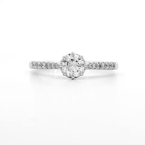 18K White gold ring featuring a round brilliant diamond center stone and accented with diamonds down the shank. Item J34776 - ABC Jewelry Co.