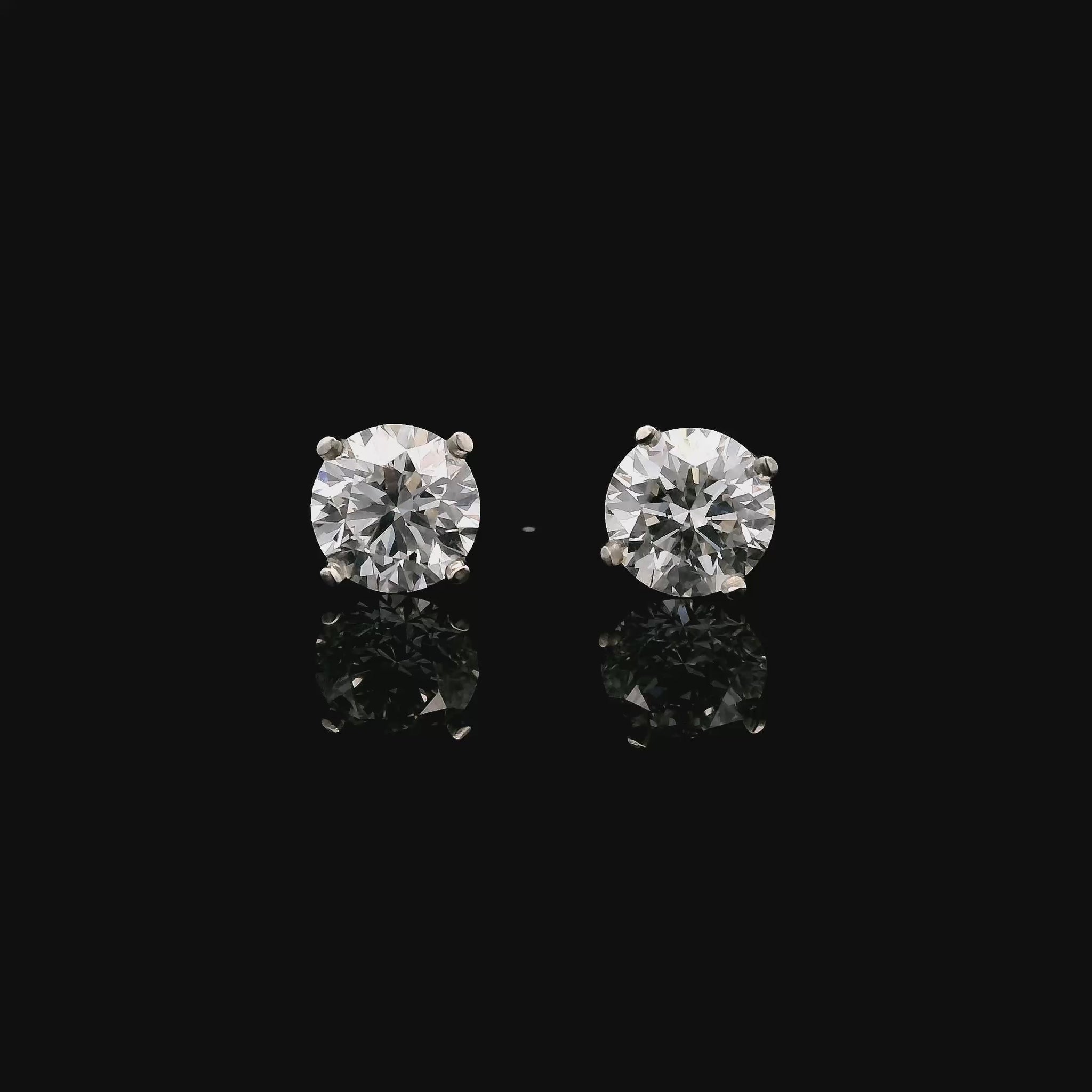 14K White gold stud earrings set with 2 round brilliant diamonds. Item J34919 - ABC Jewelry Co. 
