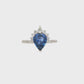 18K White gold ring set with a pear shape blue sapphire crowned with diamonds. Item J36871 - ABC Jewelry Co. 