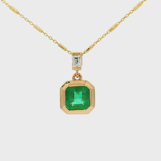 14K Yellow gold pendant necklace set with an asscher cut emerald and a baguette diamond. Item J38223 - ABC Jewelry Co. 