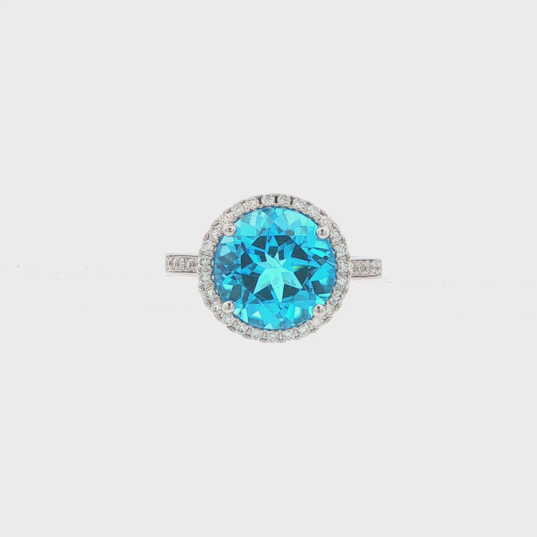 14K White gold ring with a round blue topaz and diamond halo. Item J38755 - ABC Jewelry Co. 
