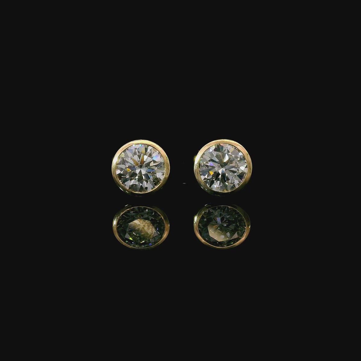 Yellow gold bezel set stud earrings set with round brilliant diamonds