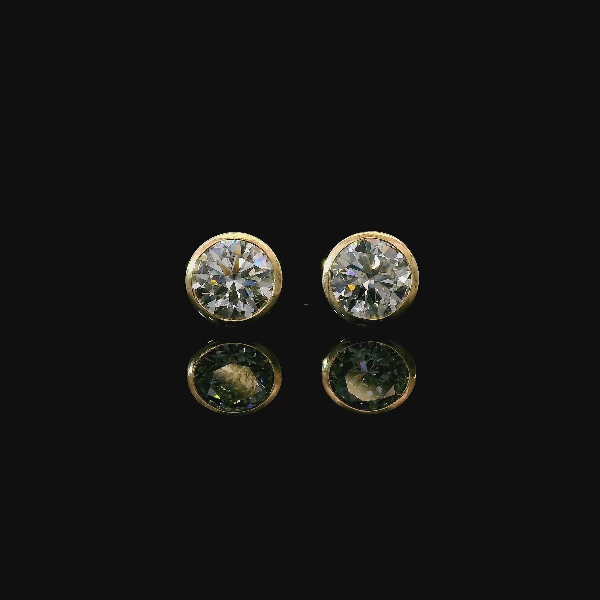 Yellow gold bezel set stud earrings set with round brilliant diamonds