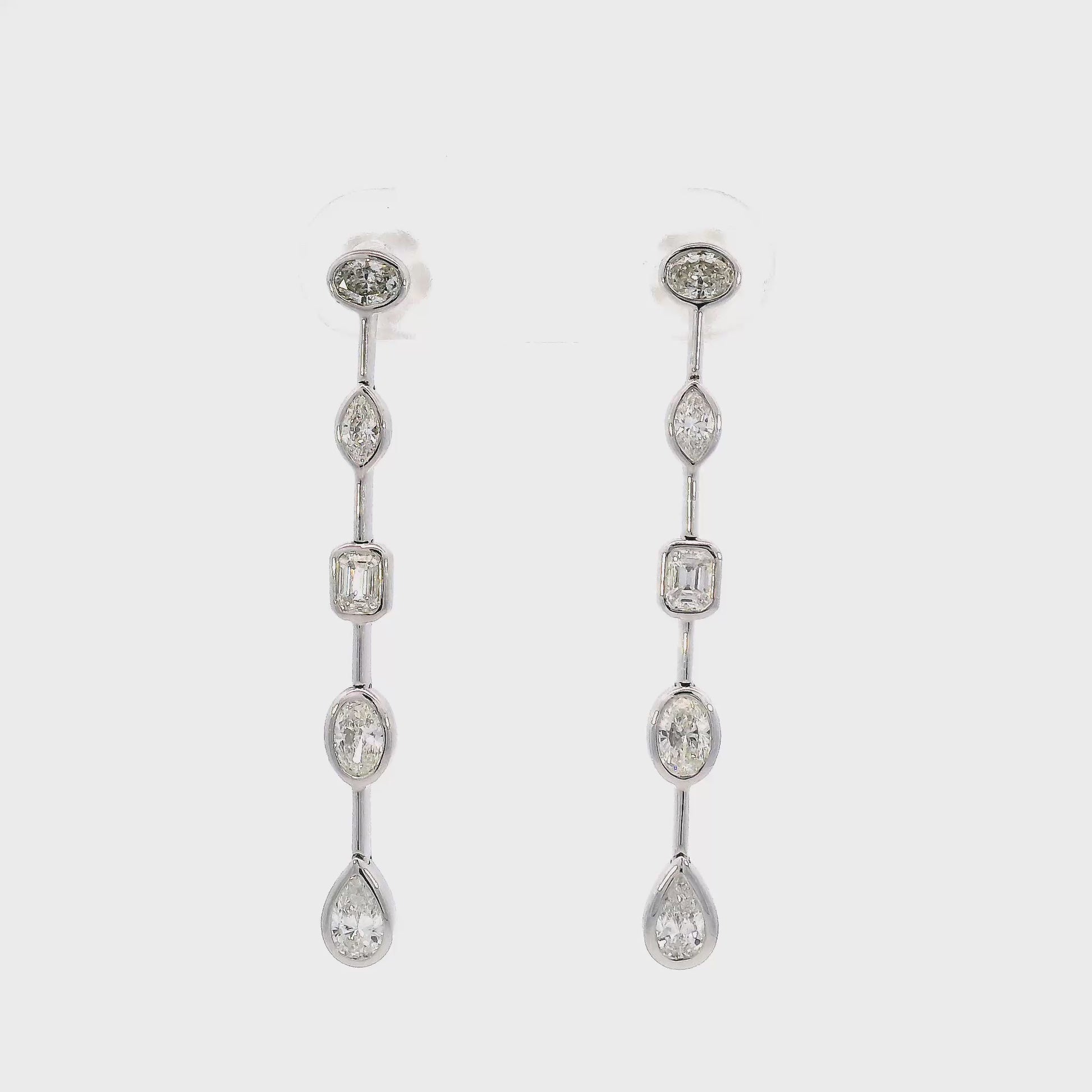 18K White gold dangle earrings featuring diamonds of assorted shapes. Item J37723 - ABC Jewelry Co