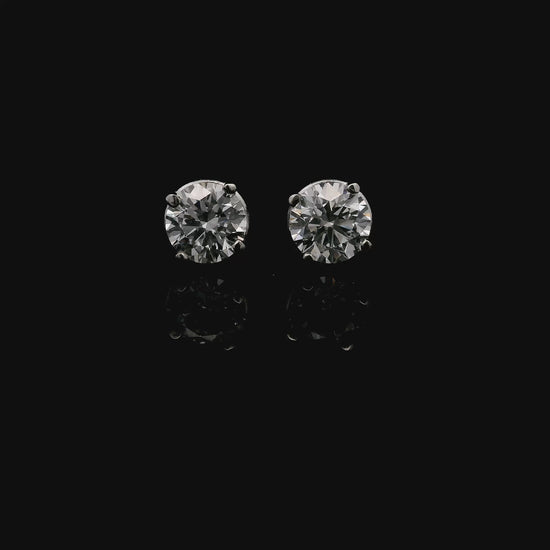14K White gold stud earrings set with 2 round brilliant diamonds. Item J34919 - ABC Jewelry Co. 