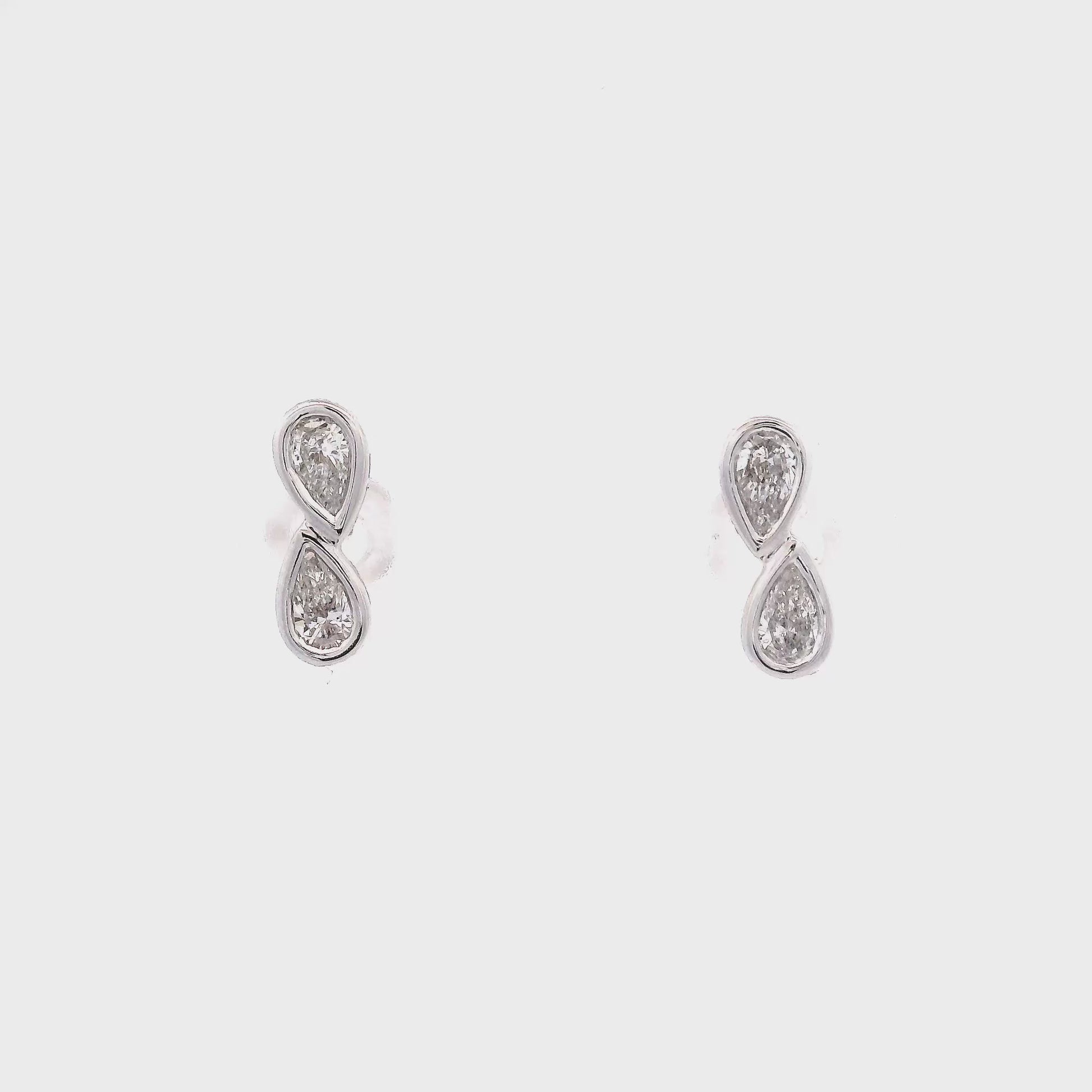 18K White gold diamond earrings, each set with two pear shape diamonds in a vertical design. Item J37096 - ABC Jewelry Co