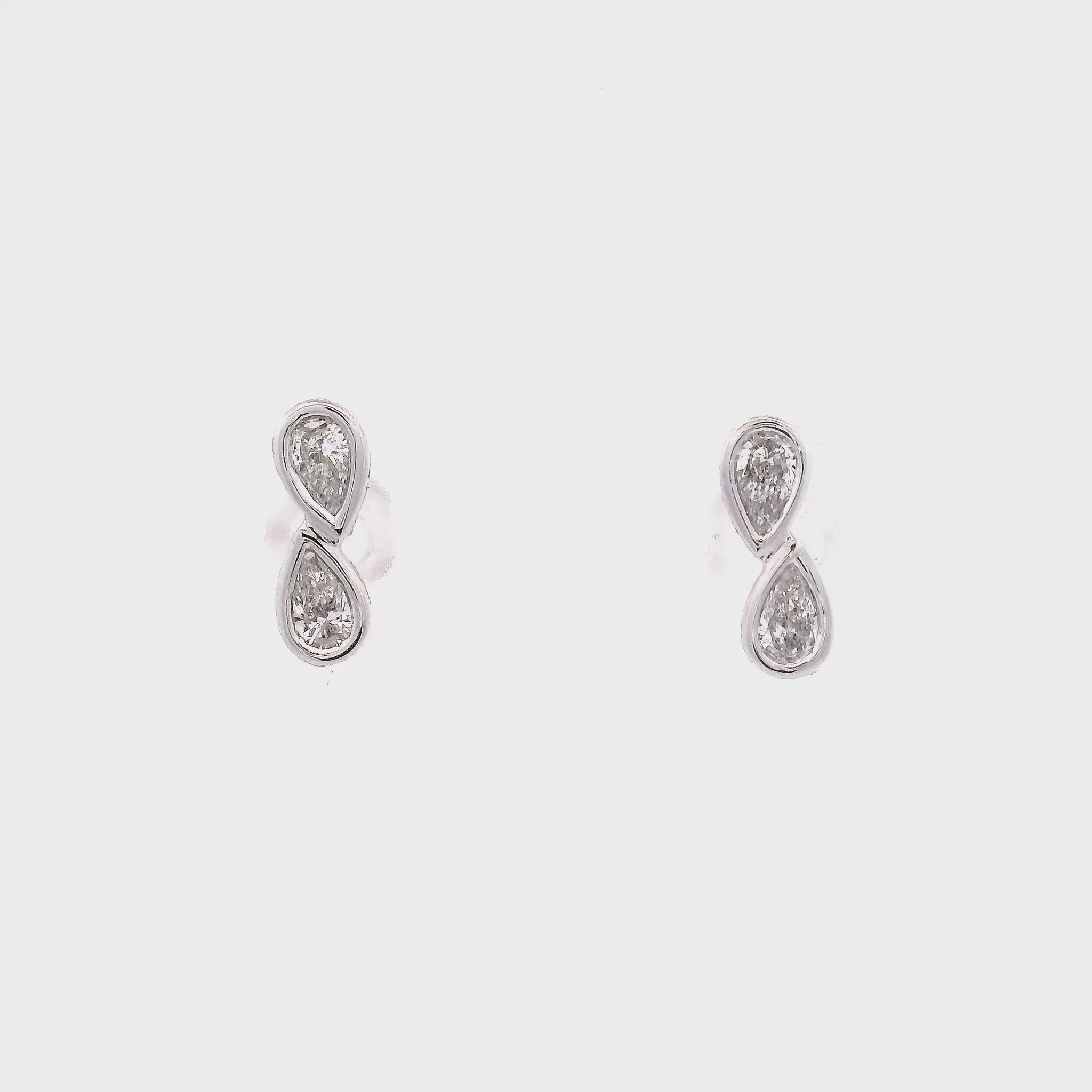 18K White gold diamond earrings, each set with two pear shape diamonds in a vertical design. Item J37096 - ABC Jewelry Co