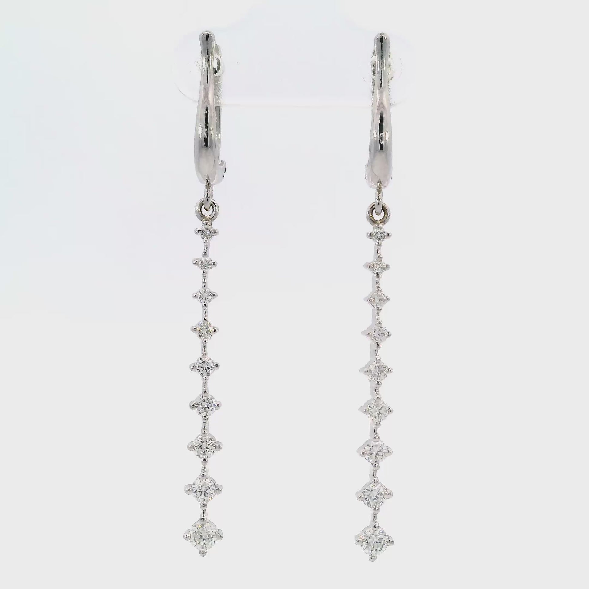 18K White gold dangle earrings with a vertical cascade of round brilliant diamonds. Item J36006 - ABC Jewelry Co