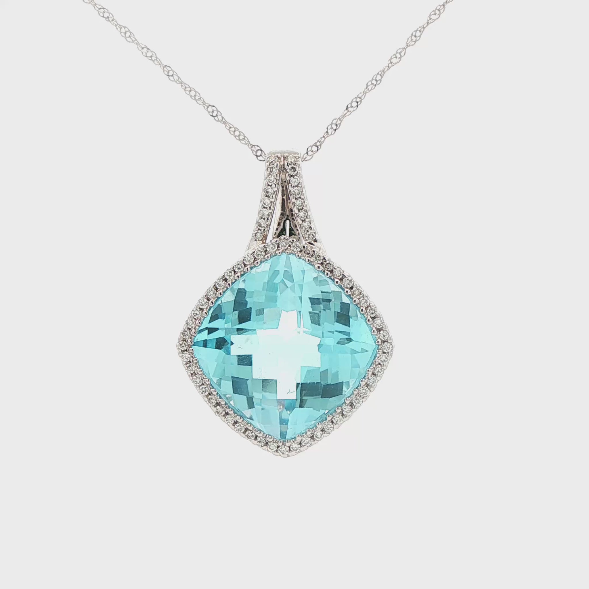 14K White gold pendant set with a blue topaz and a diamond halo. Item J38767 - ABC Jewelry Co.