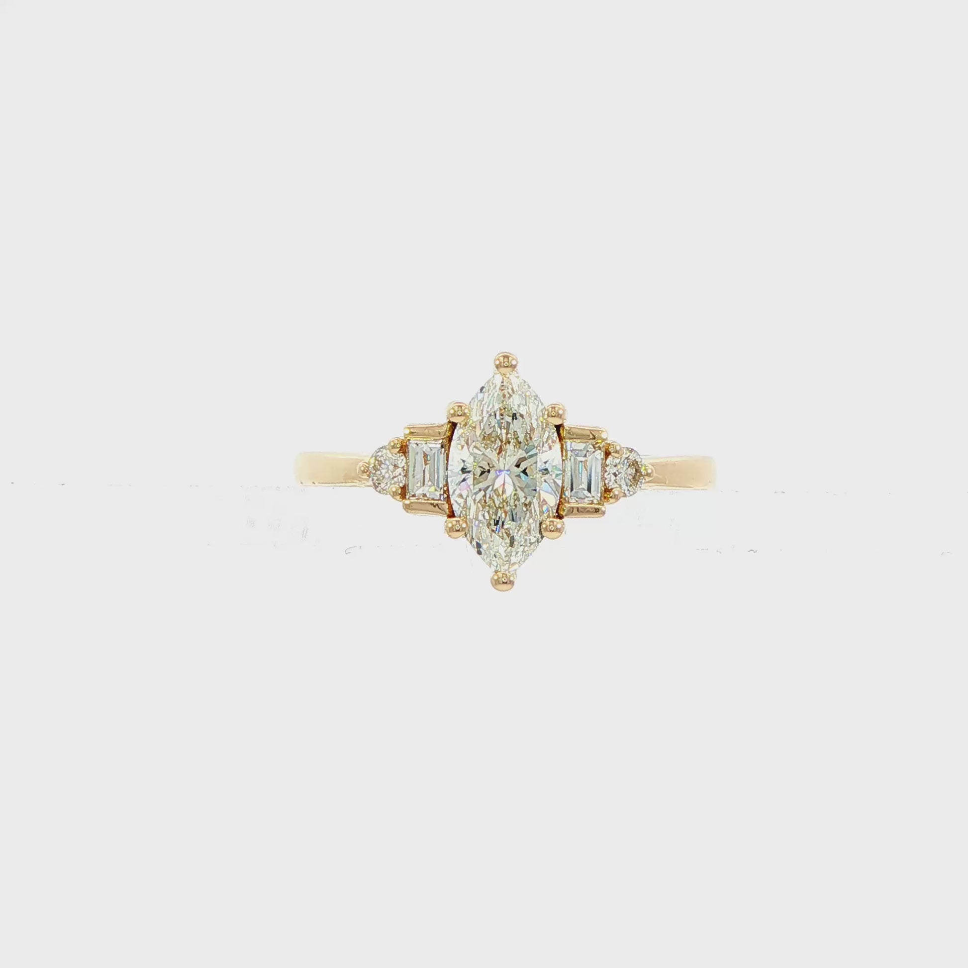 14K Yellow gold ring set with a marquise diamond flanked by baguette and round brilliant diamonds. Item J38803 - ABC Jewelry Co.