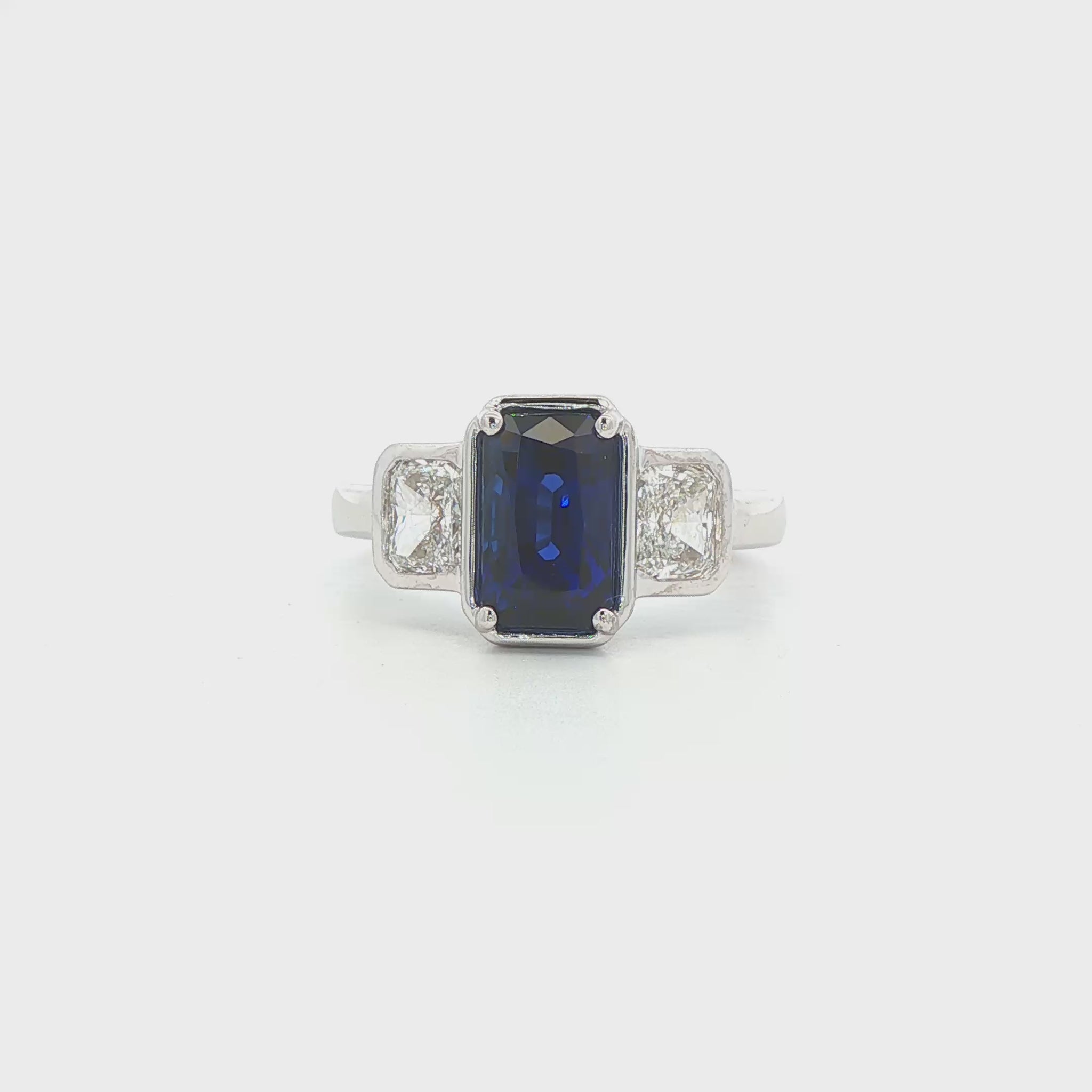 14K White gold ring set with an emerald cut sapphire and two diamonds. Item J39215 - ABC Jewelry Co. 