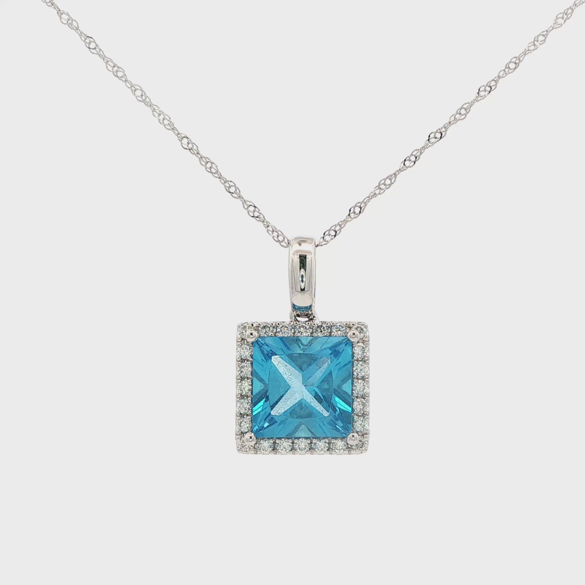 14K White gold pendant set with blue topaz and a diamond halo. Item J38757 - ABC Jewelry Co.