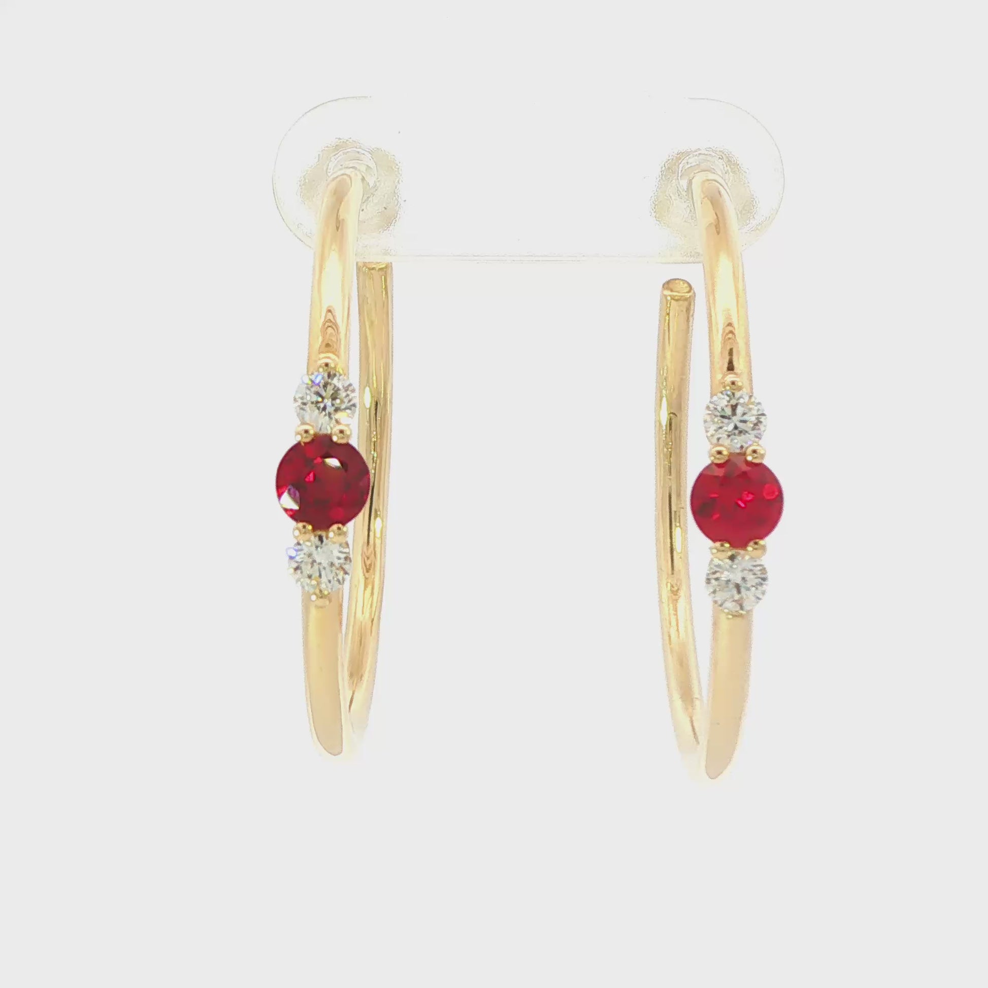 14K Yellow gold hoop earrings, each set with a round ruby flanked by two round diamonds. Item - J39018 - ABC Jewelry Co. 