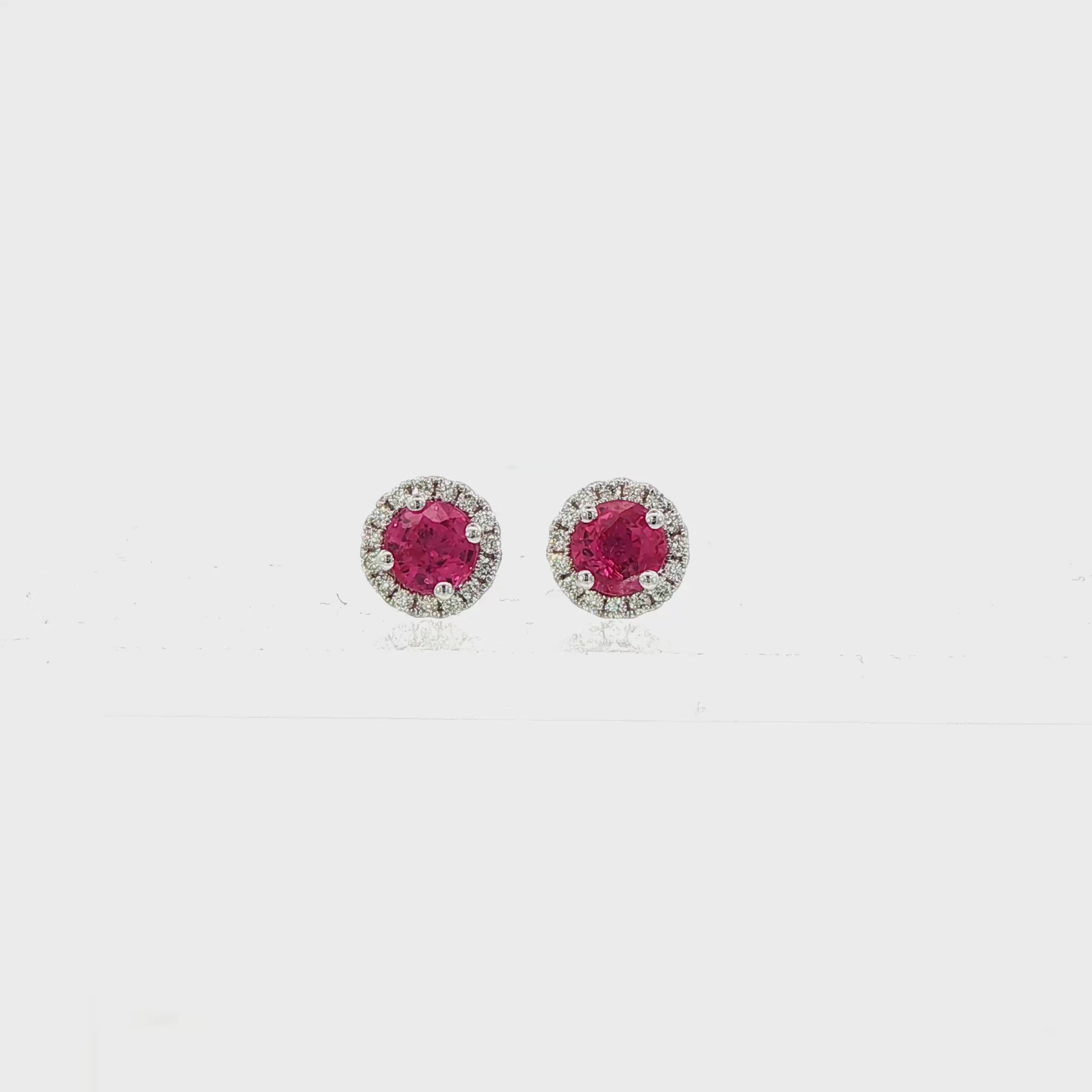 14K White gold earrings set with round rubies surrounded by a diamond halo. Item J38962 - ABC Jewelry Co. 
