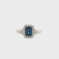 14K White gold ring set with an emerald cut deep blue sapphire surrounded by a halo of round brilliant diamonds. Item J35826 - ABC Jewelry Co. 