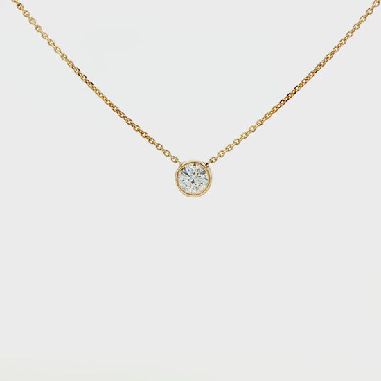 14K Yellow gold solitaire necklace with a bezel set round brilliant diamond. Item J36073 - ABC Jewelry Co. 