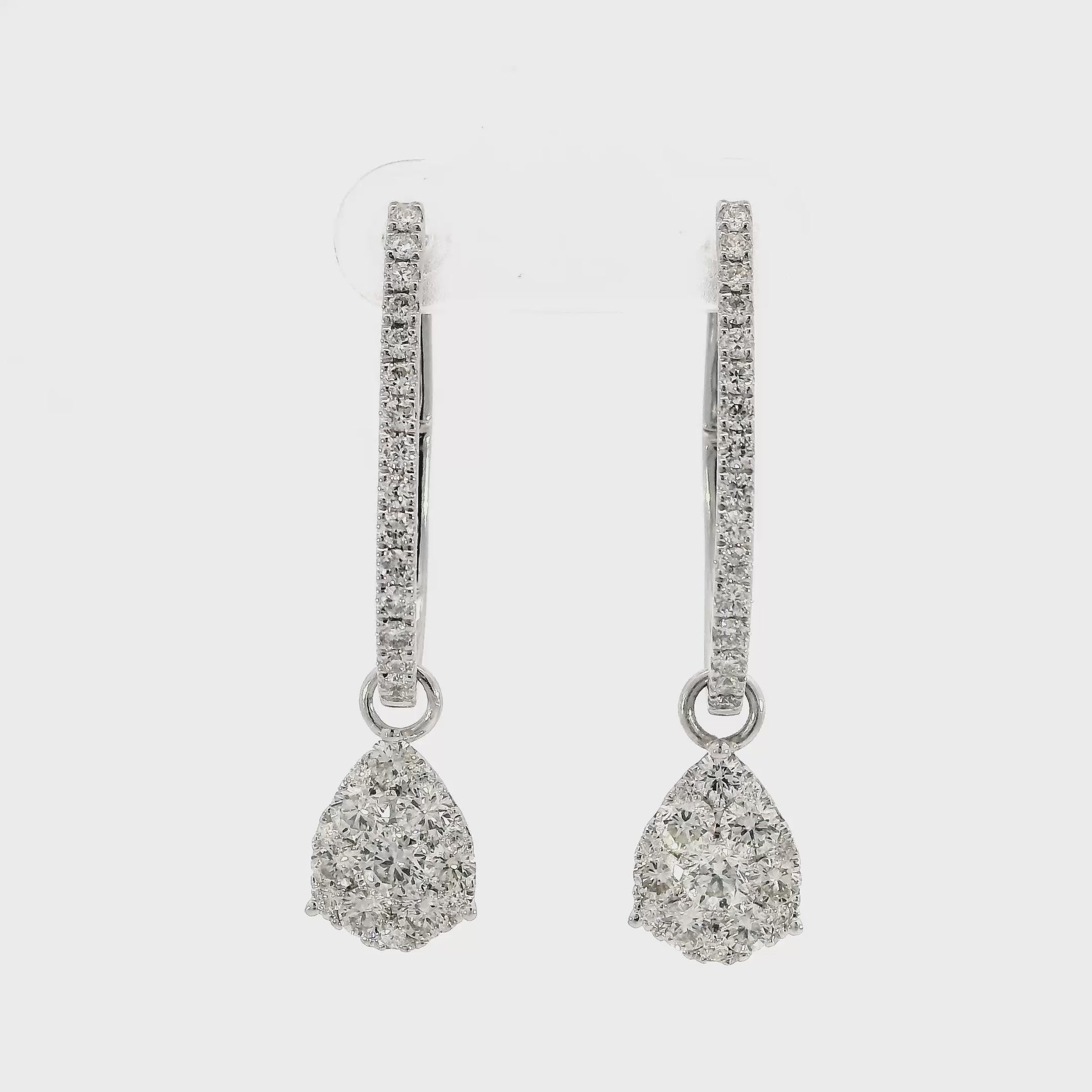 18K White gold earring jackets featuring clusters of diamonds, shown on white gold diamond hoop earrings. Item J35758 - ABC Jewelry Co