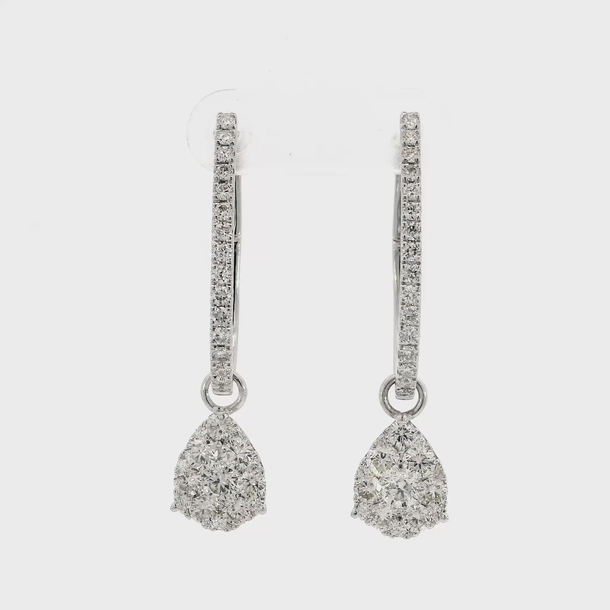 18K White gold earring jackets featuring clusters of diamonds, shown on white gold diamond hoop earrings. Item J35758 - ABC Jewelry Co