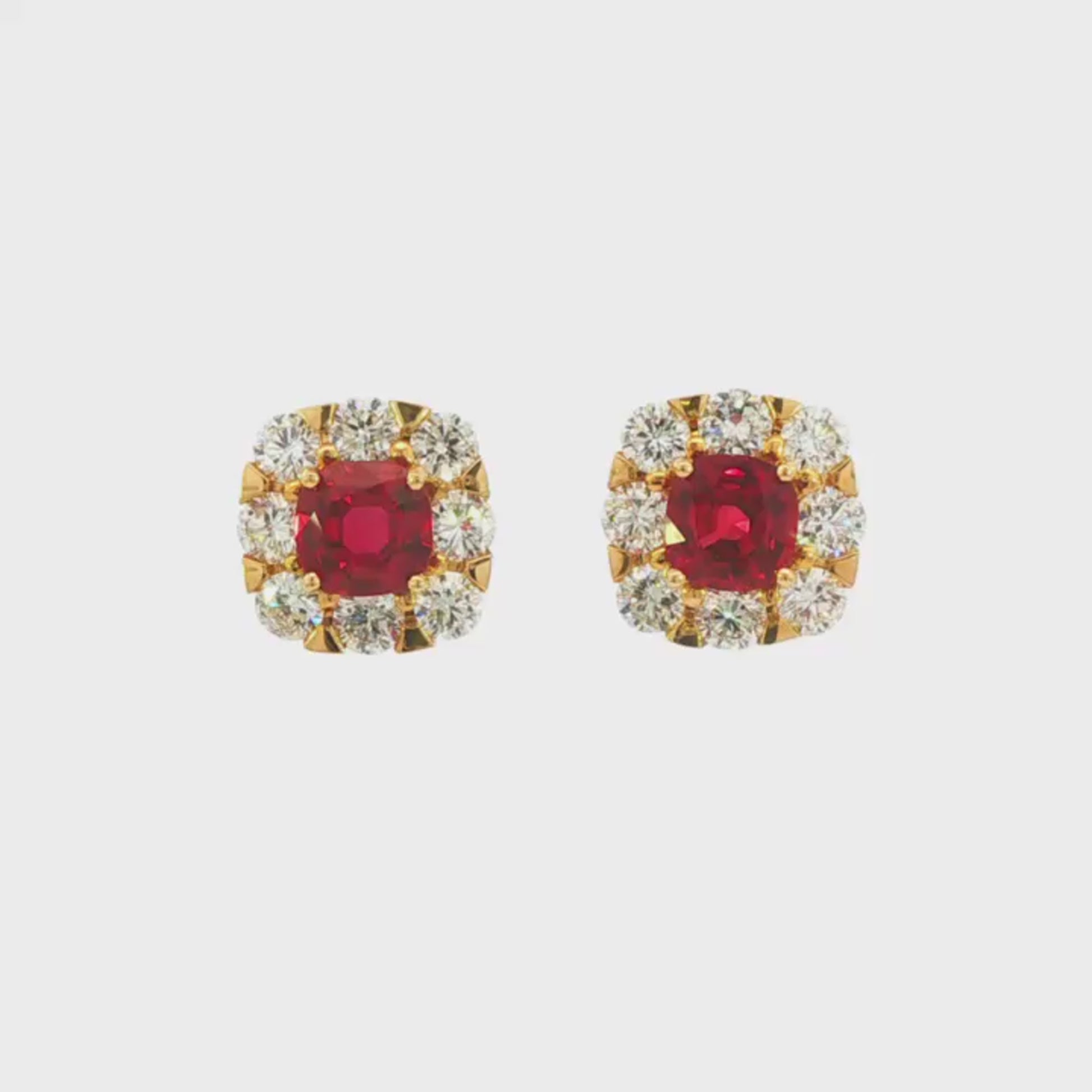 18K Yellow gold earrings set with round red rubies surrounded by a halo of round brilliant diamonds. Item J35757 - ABC Jewelry Co.